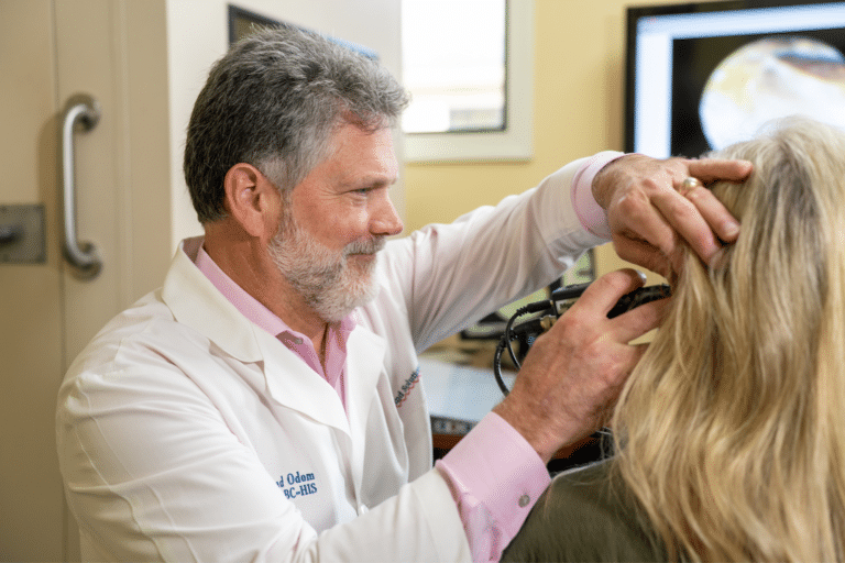 Using an otoscope on a patient.