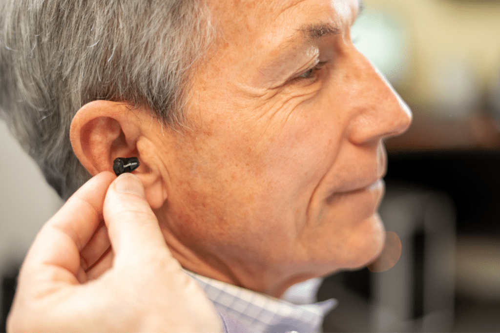 man receiving hearing aids