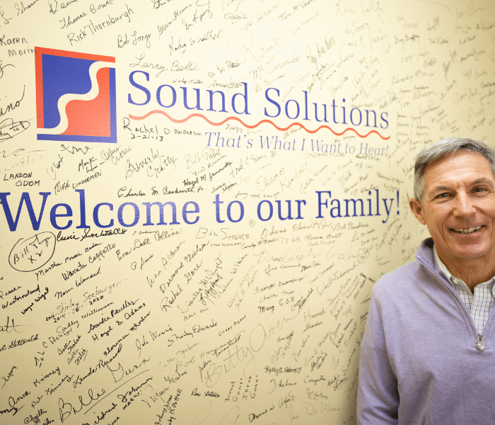 male patient in front of company logo