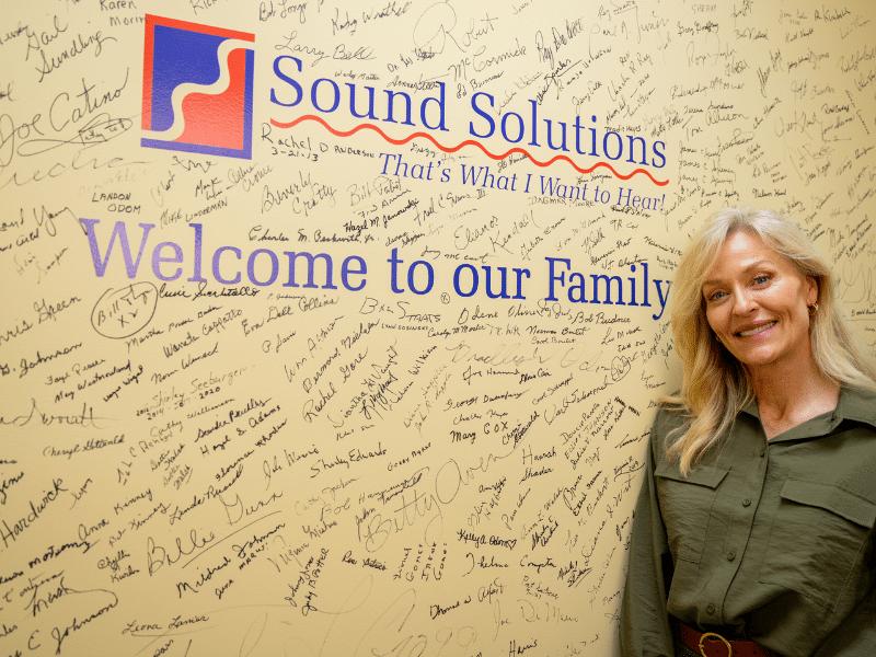 Female patient in front of company logo